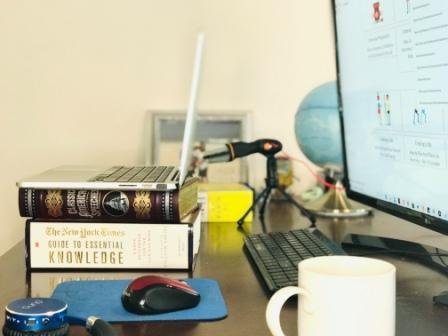 Laptop on stacks of books under the laptop to bring the camera to eye level